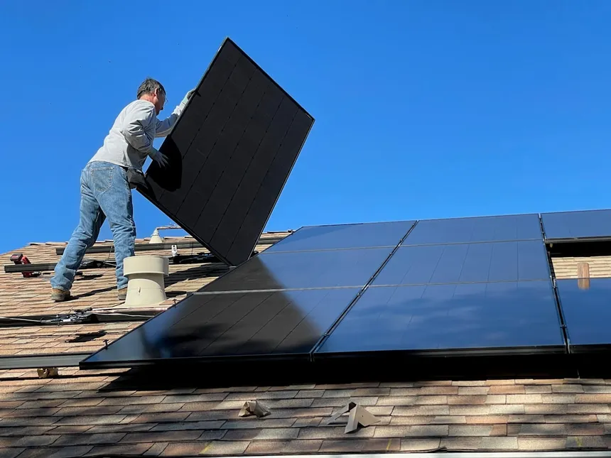 戸建て住宅の屋根に太陽光パネルを設置する様子